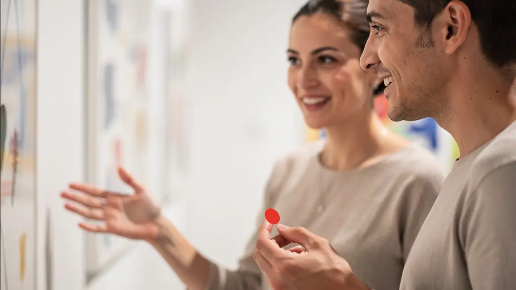 Nahaufnahme eines Gesprächs zwischen Galerist und Kunstinteressiertem vor abstraktem Kunstwerk